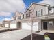 Exterior view of gray townhomes with two car garages and manicured front yard at 6296 Wasco Dr, Whitestown, IN 46075