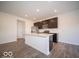 An open kitchen features an island, stainless steel appliances, and dark wood cabinets at 6296 Wasco Dr, Whitestown, IN 46075
