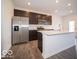 A modern kitchen features stainless steel appliances, a kitchen island, and dark wood cabinets at 6296 Wasco Dr, Whitestown, IN 46075