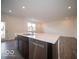 A kitchen island features dark wood cabinets, a stainless steel dishwasher, and a dual sink at 6296 Wasco Dr, Whitestown, IN 46075