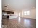 Open-concept living area with modern kitchen, stainless appliances, and luxury vinyl plank flooring at 6296 Wasco Dr, Whitestown, IN 46075