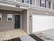 Close-up exterior featuring the garage, front door, brick accents and gray siding of the townhome at 6304 Wasco Dr, Whitestown, IN 46075