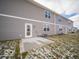 Back of home showcasing gray siding, windows, and a small patio space at 6304 Wasco Dr, Whitestown, IN 46075