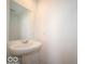Simple powder room featuring a pedestal sink, large mirror, and crisp white walls at 6304 Wasco Dr, Whitestown, IN 46075