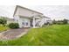 Backyard view with a covered patio and a spacious, well-maintained lawn and garden at 1220 Greenwood Station Blvd, Greenwood, IN 46143