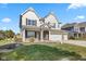 Charming two-story home featuring brick accents, white trim, a manicured lawn, and a three car attached garage at 1220 Greenwood Station Blvd, Greenwood, IN 46143