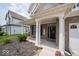 Covered front porch of this home is supported by white columns with a seating bench at 1220 Greenwood Station Blvd, Greenwood, IN 46143