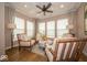 Cozy living room with neutral armchairs around a round table, large windows, and hardwood floors at 1220 Greenwood Station Blvd, Greenwood, IN 46143