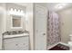 Well-lit bathroom with a vanity, granite countertop, tiled backsplash, and a shower with a decorative curtain at 2747 E Midland Rd, Indianapolis, IN 46227