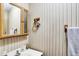Close-up of half bathroom showing vanity, mirror, and wallpapered walls at 2747 E Midland Rd, Indianapolis, IN 46227