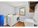 Functional laundry room featuring a washer, dryer, utility sink, and storage cabinets at 2747 E Midland Rd, Indianapolis, IN 46227