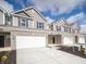 New construction townhome with a two-car garage, brick accents and landscaped front yard at 6314 Wasco Dr, Whitestown, IN 46075
