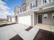 New construction townhome with a two-car garage, brick accents and neutral siding at 6314 Wasco Dr, Whitestown, IN 46075