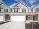 New construction townhome with a two-car garage, brick accents and neutral siding at 6314 Wasco Dr, Whitestown, IN 46075
