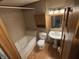 Traditional bathroom with a built-in tub, pedestal sink, mirrored cabinet, and wood-look flooring at 8855 N Waverly Park Rd, Martinsville, IN 46151