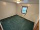 Empty bedroom with green carpet, neutral walls, and a window with blinds to let in natural light at 8855 N Waverly Park Rd, Martinsville, IN 46151