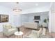 Bright living room with a stone fireplace, a modern lighting fixture, and light hardwood floors at 2068 S Avon Ave, Avon, IN 46123