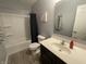 Bright bathroom with a vanity sink, toilet, and shower-tub combo with a dark blue curtain at 2018 Abbey Ln, Columbus, IN 47201