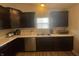 Close-up view of a kitchen with stainless steel appliances, dark cabinets, and a double sink at 2018 Abbey Ln, Columbus, IN 47201