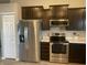 Kitchen with stainless steel fridge and oven, dark cabinets and a white pantry door at 2018 Abbey Ln, Columbus, IN 47201