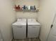 Cozy laundry area featuring a washer, dryer, and storage shelf at 2018 Abbey Ln, Columbus, IN 47201