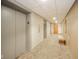 An empty condo hallway with carpeting leads to suite doors and elevators at 4000 N Meridian St # 14A, Indianapolis, IN 46208
