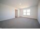 Spacious bedroom with large window and neutral carpet offers a blank canvas at 7888 Magnolia St, New Palestine, IN 46163