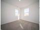 Well-lit bedroom with two windows providing natural light and neutral-toned carpeting at 7888 Magnolia St, New Palestine, IN 46163