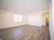 Open bedroom featuring wood-look flooring, recessed lights, and natural light from a well-placed window at 7888 Magnolia St, New Palestine, IN 46163
