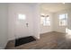 Bright entryway featuring wood-look flooring, a stylish front door, and natural light from adjacent windows at 7888 Magnolia St, New Palestine, IN 46163