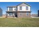 Two-story home showcasing a brick and vinyl exterior, complemented by a well-maintained lawn under a clear blue sky at 7888 Magnolia St, New Palestine, IN 46163