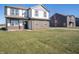 View of the front exterior of the home with lawn and neighboring houses, under a clear, sunny sky at 7888 Magnolia St, New Palestine, IN 46163