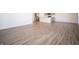 Spacious living area with wood-look floors, flowing into a kitchen area with modern stainless appliances at 7888 Magnolia St, New Palestine, IN 46163