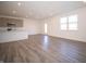 Open concept living area with wood-look flooring, flowing to a kitchen with modern cabinetry and stainless appliances at 7888 Magnolia St, New Palestine, IN 46163