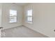 Bright bedroom with neutral carpet and two windows, offering a cozy and comfortable space at 3567 Windstar Ct, Columbus, IN 47203