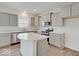 A bright kitchen features gray cabinets, an island, stainless steel appliances, and quartz countertops at 3567 Windstar Ct, Columbus, IN 47203