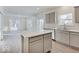 An open kitchen features gray cabinets, an island, stainless steel appliances, and quartz countertops at 3567 Windstar Ct, Columbus, IN 47203