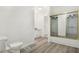 Bright bathroom featuring a toilet, new flooring, and a shower with glass doors at 1127 S Pershing Ave, Indianapolis, IN 46221