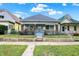 Charming bungalow-style home with blue siding and red brick accents, framed by a chain-link fence and colorful flower boxes at 1127 S Pershing Ave, Indianapolis, IN 46221