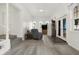 Bright and airy living room showcasing hardwood floors, neutral walls, and a cozy seating arrangement near the entrance at 1127 S Pershing Ave, Indianapolis, IN 46221