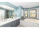 Bright bathroom featuring a double vanity, soaking tub, and walk-in shower with modern fixtures and stylish tiling at 5826 Winding Way Ln, Indianapolis, IN 46220