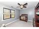 Neutral-toned Bedroom with a classic wooden crib, ceiling fan, and natural light from the window at 5826 Winding Way Ln, Indianapolis, IN 46220