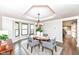 Elegant dining room with dark wood floors, modern chandelier, and a view of the bay window at 5826 Winding Way Ln, Indianapolis, IN 46220