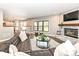 Bright living room features a brick fireplace, dark brown leather sectional, and large windows at 5826 Winding Way Ln, Indianapolis, IN 46220