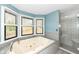 Bright main bathroom featuring a large soaking tub, tiled shower, and plenty of natural light at 5826 Winding Way Ln, Indianapolis, IN 46220