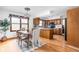 Cozy dining area adjacent to kitchen, featuring wood floors and ample natural light from the window at 7655 Westerville Dr, Clayton, IN 46118