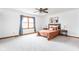 Light-filled main bedroom boasting a large window, ceiling fan and neutral color palette at 7655 Westerville Dr, Clayton, IN 46118