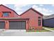 Modern home featuring a dark garage door and red siding, complemented by tidy landscaping at 1676 Solebar Way, Westfield, IN 46074