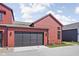 Exterior showcasing the home's red siding, a dark garage door, and freshly installed landscaping at 1676 Solebar Way, Westfield, IN 46074