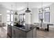 Modern kitchen with a black island, gray cabinets, and a view of the open living space at 1676 Solebar Way, Westfield, IN 46074